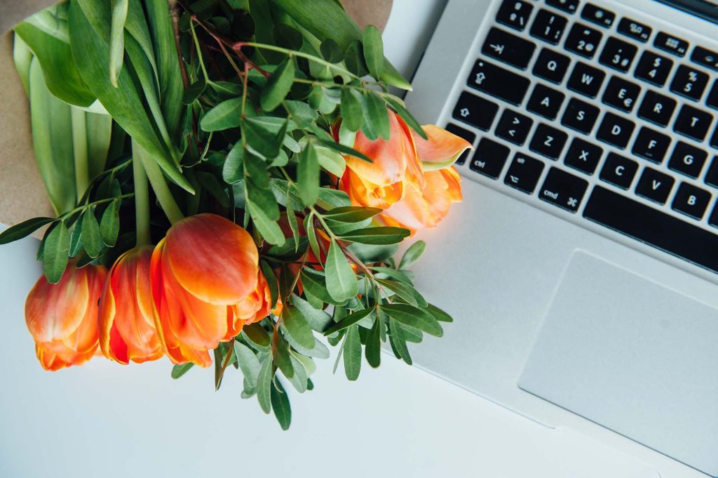 Humanização no Ambiente de Trabalho: O Papel Transformador das Flores 14 computador portatil no chao branco com flores